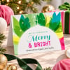 Festive Spirit Christmas Cards Folded on a table with gifts and baubles