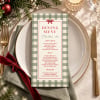 Plaid Christmas menu on a festive table setting with gold cutlery, a sage napkin and a red velvet ribbon